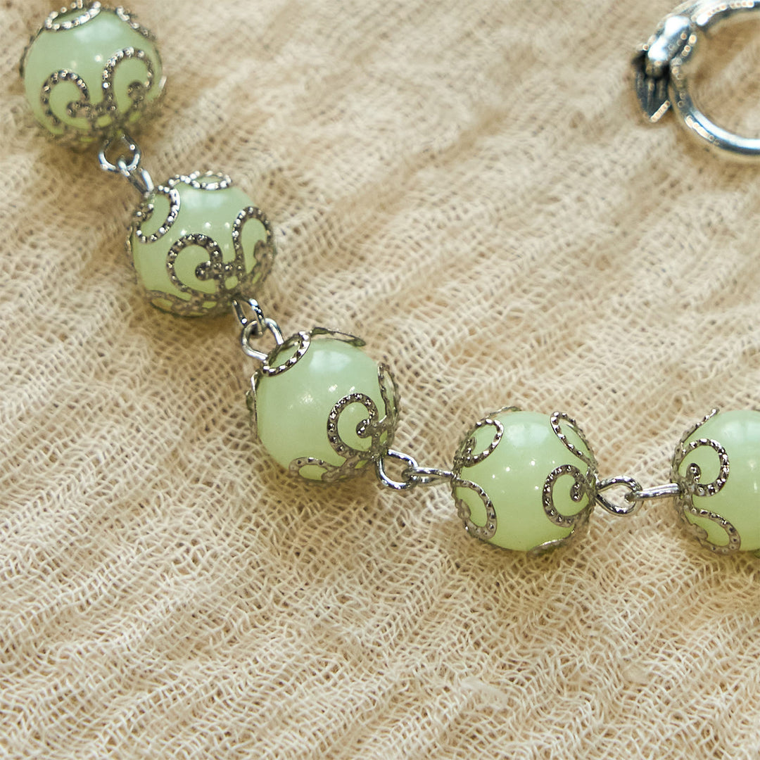 Christianartworkshop Leuchtendes Armband mit grünen Perlen und Kruzifix in Rose: Verträumtes Licht des Glaubens