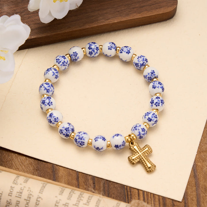 Christianartworkshop Elastisches Armband mit vier floralen Keramikperlen und goldfarbenem Kreuzanhänger: Ein Symbol sanfter himmlischer Gnade - Blau - image 2