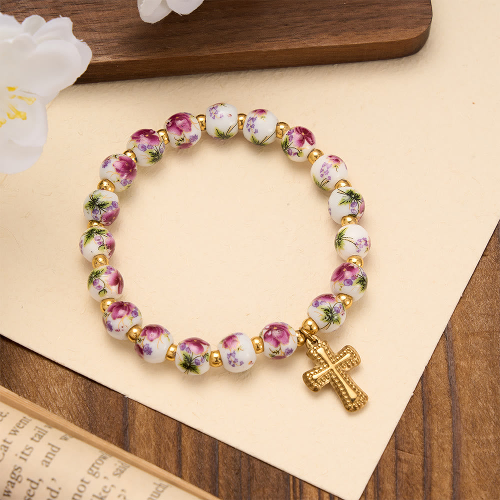 Christianartworkshop Elastisches Armband mit vier floralen Keramikperlen und goldfarbenem Kreuzanhänger: Ein Symbol sanfter himmlischer Gnade - Lila - image 0