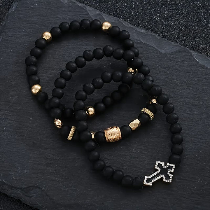 Christianartworkshop Mehrlagiges, dehnbares Armband aus mattschwarzen Steinperlen mit Zirkonia-Kreuz und gravierten Goldzwischenstücken - image 6