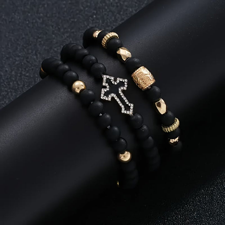 Christianartworkshop Mehrlagiges, dehnbares Armband aus mattschwarzen Steinperlen mit Zirkonia-Kreuz und gravierten Goldzwischenstücken - image 4
