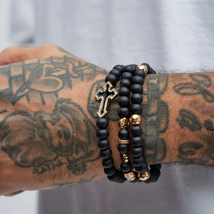 Christianartworkshop Mehrlagiges, dehnbares Armband aus mattschwarzen Steinperlen mit Zirkonia-Kreuz und gravierten Goldzwischenstücken - image 5