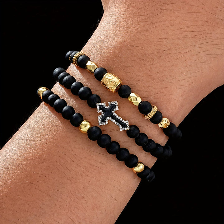 Christianartworkshop Mehrlagiges, dehnbares Armband aus mattschwarzen Steinperlen mit Zirkonia-Kreuz und gravierten Goldzwischenstücken - 3-teiliges Armband - image 0