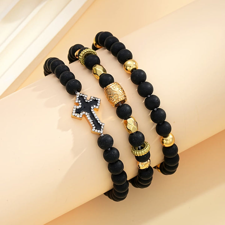 Christianartworkshop Mehrlagiges, dehnbares Armband aus mattschwarzen Steinperlen mit Zirkonia-Kreuz und gravierten Goldzwischenstücken - image 2