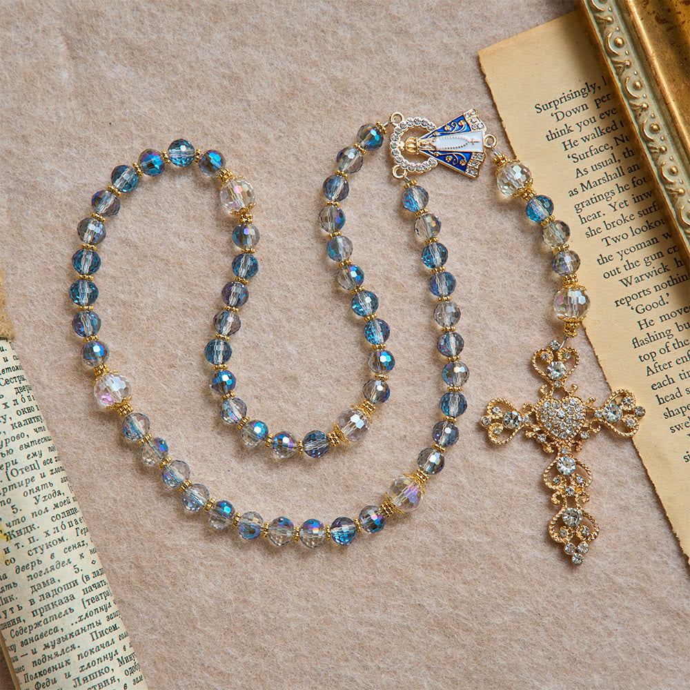 Christianartworkshop Rosenkranz aus schimmernden blauen Perlen mit der Muttergottes von Aparecida und Strasskreuz: Personalisierte Namensperlen als Erinnerungsstück für die Kapelle - image 3