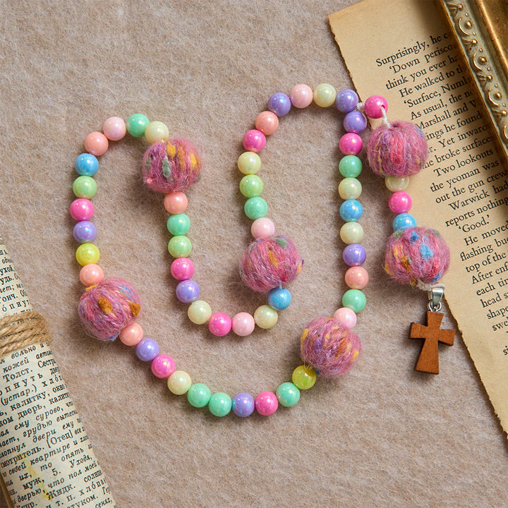 Christianartworkshop Rosenkranz für Kinder aus flauschigen Pompon-Macarons mit Holzkreuz: Symbol himmlischer Güte - Flauschiger Rosenkranz in Macaron-Farben - image 0