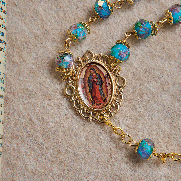 Christianartworkshop Rosenkranz aus blauem Glas mit floralem Muster, vergoldetem Kruzifix mit Rosenmotiv und Medaillon Unserer Lieben Frau von Guadalupe - image 7