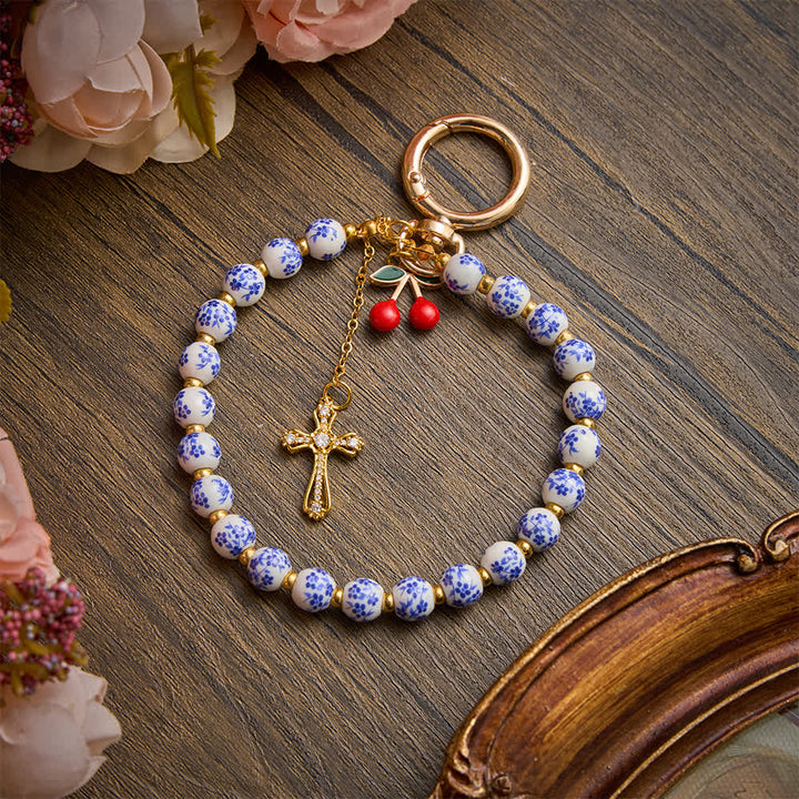 Christianartworkshop Taschenanhänger mit Kirschmotiv aus Porzellanperlen und Schmuckkreuz: Symbol sanfter himmlischer Gnade - image 2